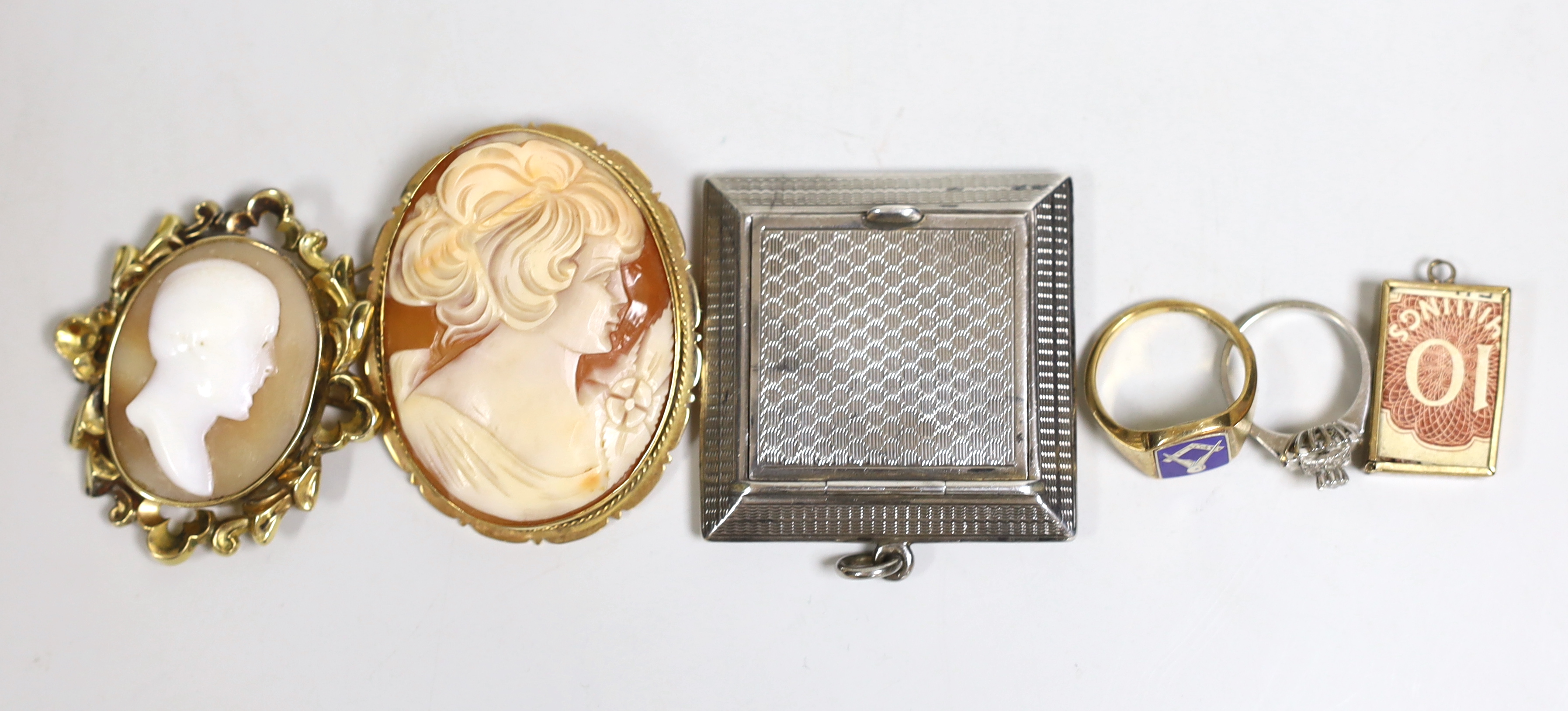 An early 1960's 9ct gold and enamel masonic ring, size P, a 9ct gold mounted oval cameo shell brooch, one other cameo brooch, a 9ct gold mounted charm, an 18ct white metal and diamond chip ring and a silver compact (lack